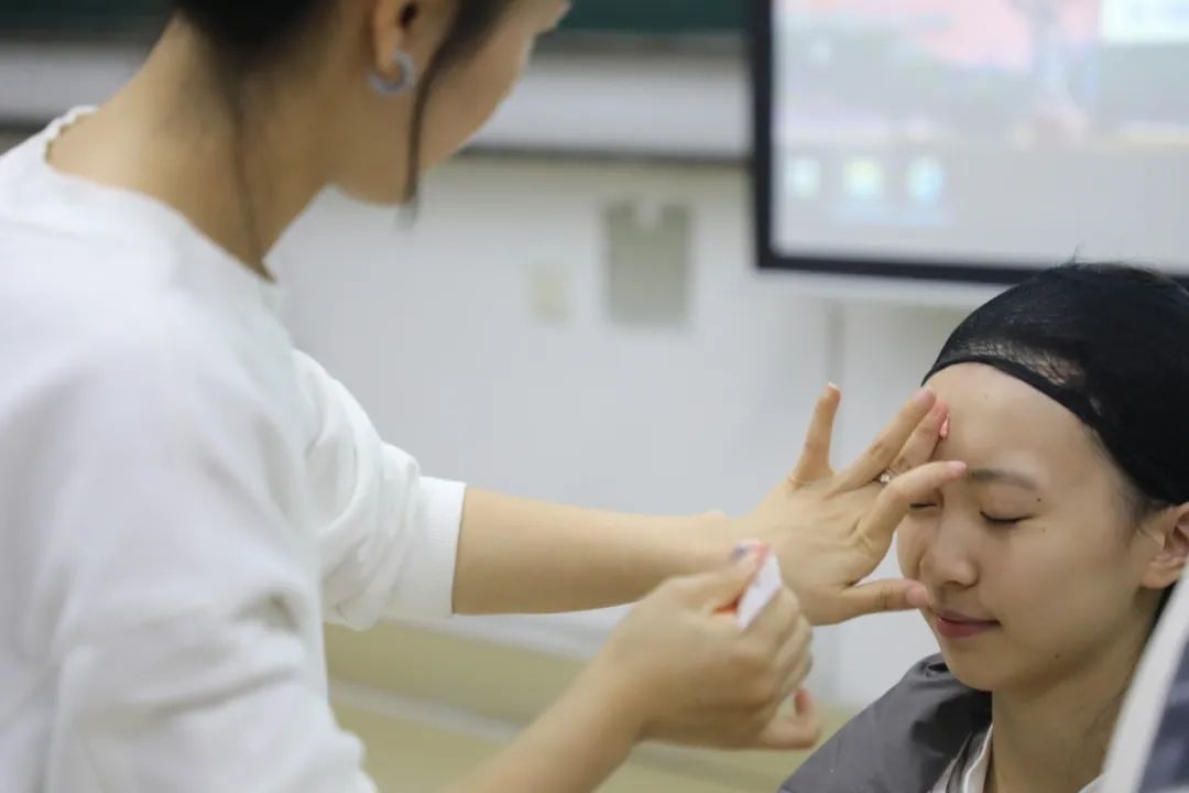 課堂上，一名學(xué)生在體驗上戲妝。學(xué)校供圖