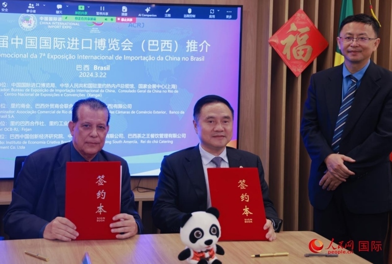 巴西外貿(mào)商會聯(lián)合會會長阿代爾·羅伯托（左）與中國國際進口博覽局副局長吳政平（中）現(xiàn)場簽訂協(xié)議。人民網(wǎng)記者 宋亦然攝
