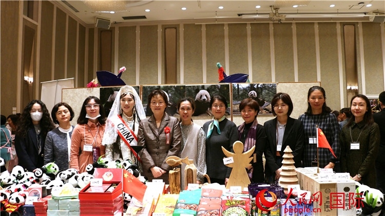 中國(guó)駐日本大使吳江浩夫人丁玥（左五）與使館人員在展位前合影留念。人民網(wǎng) 許可攝