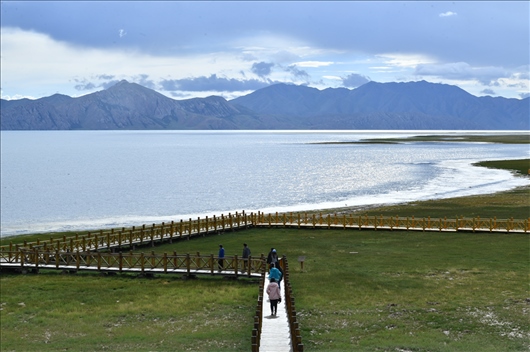 △ 游客行走在青?，敹嗫h冬格措納湖畔的木棧道上。