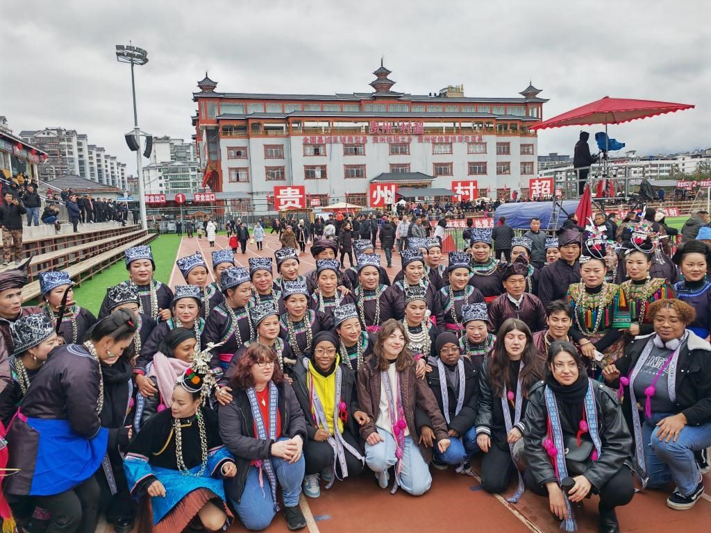 法國(guó)青年在“村超”賽場(chǎng)邊與參加表演的村民合影。新華社記者 羅羽 攝