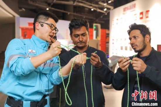 5月9日，工作人員指導(dǎo)留學(xué)生學(xué)習(xí)打繩結(jié)。張鷹 攝