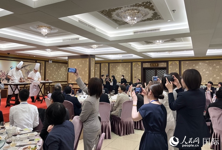 國(guó)家級(jí)非物質(zhì)文化遺產(chǎn)、全聚德片鴨工藝吸引代表團(tuán)成員拍照留念。