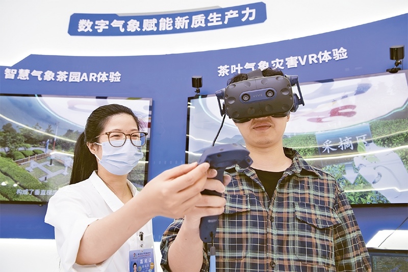 2024年5月23日，第七屆數(shù)字中國建設峰會現(xiàn)場體驗區(qū)在福州海峽國際會展中心向?qū)I(yè)觀眾開放。本次現(xiàn)場體驗區(qū)圍繞本屆峰會主題“釋放數(shù)據(jù)要素價值，發(fā)展新質(zhì)生產(chǎn)力”，設置“數(shù)字惠民”、“數(shù)字能力”、“數(shù)字基礎”、“數(shù)字生態(tài)”、“數(shù)字賦能”五大板塊。圖為一名觀眾（右）在數(shù)字氣象賦能新質(zhì)生產(chǎn)力展臺上進行體驗。 新華社記者 魏培全/攝