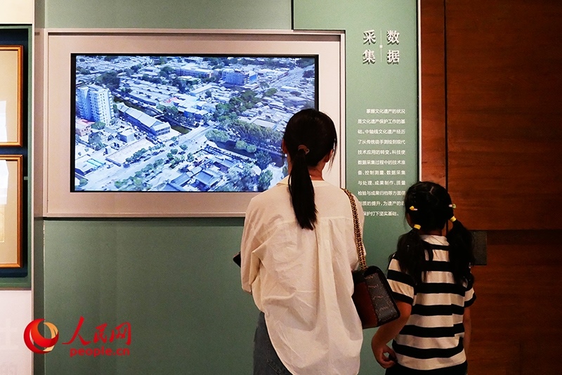 家長正在帶孩子參觀“輝煌中軸”專題展。人民網(wǎng)記者 韋衍行攝