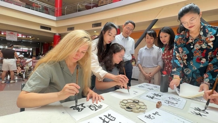 羅馬尼亞友人在活動(dòng)現(xiàn)場(chǎng)學(xué)寫漢字。中國駐羅馬尼亞大使館領(lǐng)僑處供圖