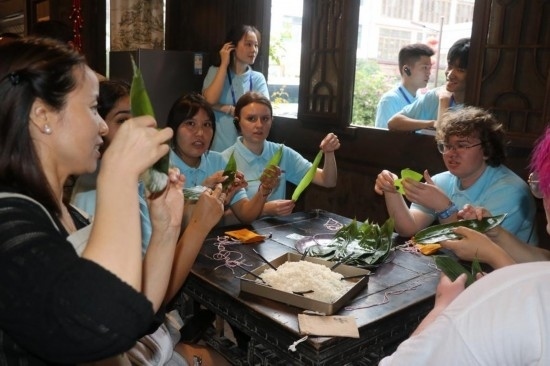 6月9日，美國(guó)青年代表在重慶永川松溉古鎮(zhèn)體驗(yàn)包粽子。新華社記者 周思宇 攝