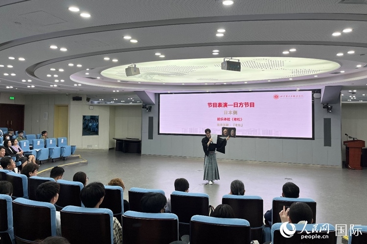 日本大學(xué)生介紹能樂知識。人民網(wǎng)記者 陳思攝