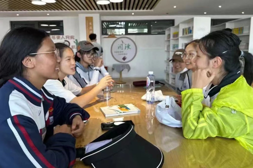 2023年7月10日，在果洛西寧民族中學(xué)，上海市大同中學(xué)學(xué)生（右）與果洛西寧民族中學(xué)學(xué)生交流。新華社發(fā)（果洛州教育局供圖）
