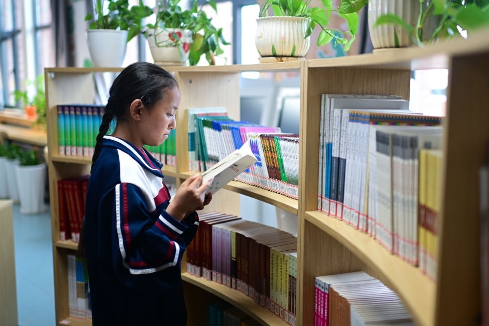 6月18日，果洛西寧民族中學(xué)學(xué)生尼東拉毛在圖書室看書。