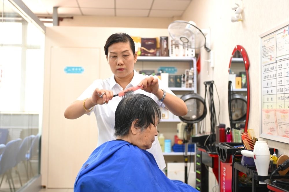 6月20日，長(zhǎng)城花園社區(qū)的志愿者為居民理發(fā)。