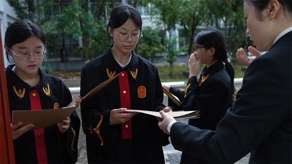 圖①：武平法院干警向?qū)W生分發(fā)道具卷宗。