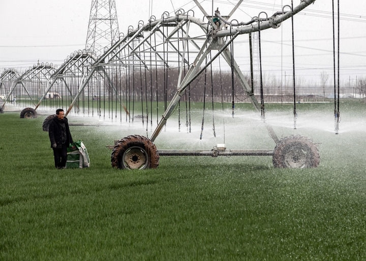 2024年3月18日，在河南省焦作市博愛縣孝敬鎮(zhèn)東原莊村瑞輝家庭農(nóng)場，村民使用全自動(dòng)指針式噴灌機(jī)進(jìn)行澆灌作業(yè)。新華社發(fā)（程全攝）