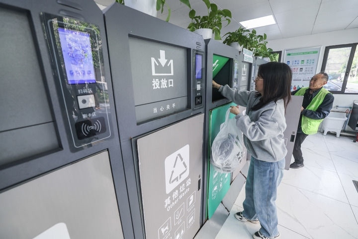 2024年4月10日，在浙江省湖州市吳興區(qū)飛英街道新華府小區(qū)內(nèi)，居民在垃圾分類智能系統(tǒng)的指導(dǎo)下進(jìn)行垃圾分類投放，居民的投放情況將實(shí)時(shí)匯總到智慧服務(wù)平臺(tái)，會(huì)有相應(yīng)的積分獎(jiǎng)勵(lì)。新華社記者 徐昱 攝