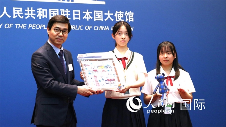 日本小大使向中國駐日本大使館臨時代辦施泳贈送當?shù)靥厣Y品。人民網(wǎng) 許可攝