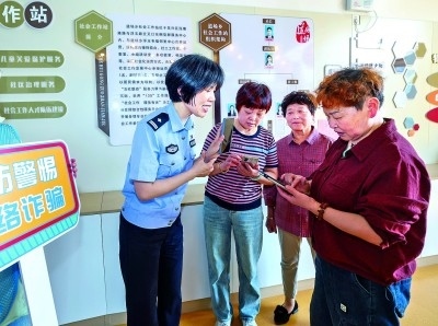 浙江湖州民警指導(dǎo)居民加入湖州“e企安”微信群，實(shí)時(shí)接收反詐信息。新華社發(fā)