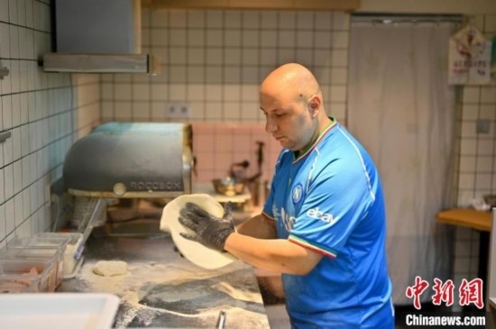 近日，韋榮耀在自家披薩小店內(nèi)忙活。俞靖 攝