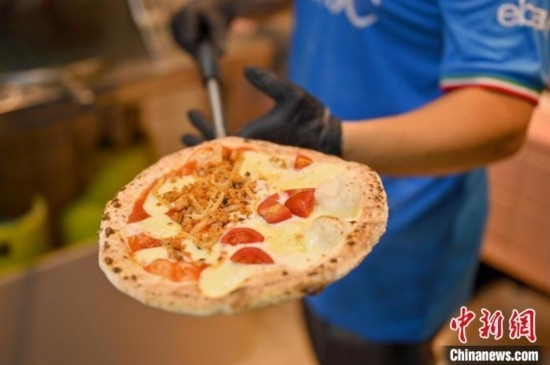 近日，韋榮耀展示他制作的“老友味”披薩。 俞靖 攝