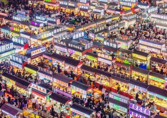 2024年4月21日，人們?cè)诤颖笔≌h小商品夜市品嘗美食（無(wú)人機(jī)照片）。新華社發(fā)（武志偉 攝）