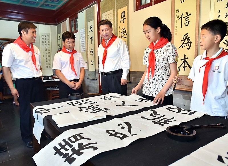 2014年5月30日，習(xí)近平總書記來到北京市海淀區(qū)民族小學(xué)，參加慶?！傲弧眹H兒童節(jié)活動。這是總書記觀看學(xué)生書寫的毛筆字。