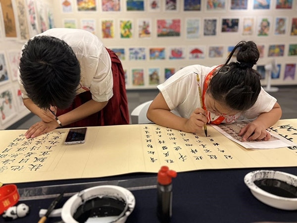 參加本次展覽的青少年在現(xiàn)場進行書法創(chuàng)作。主辦方供圖
