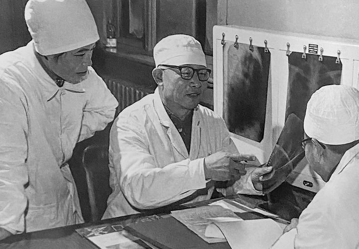 1980年1月16日，中日友好醫(yī)院首任院長辛育齡（中）在內(nèi)蒙古結(jié)核病院與胸外科醫(yī)師討論病例（翻拍照片）。 新華社發(fā)