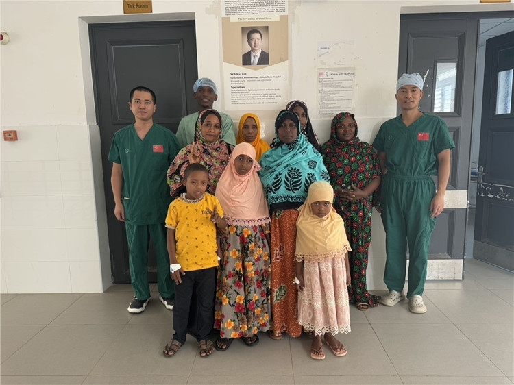 李廣（右一）和王林醫(yī)生與部分患者合影。中國援桑醫(yī)療隊供圖