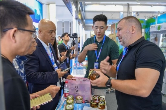 2023年8月23日，在第十四屆中國—東北亞博覽會東北亞商品館，俄羅斯參展商向參觀者介紹商品。