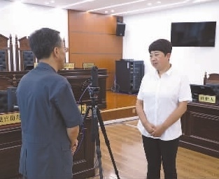 圖為全國人大代表玉明姬（右）詳細(xì)了解環(huán)境資源審判工作情況。劉思妤 攝