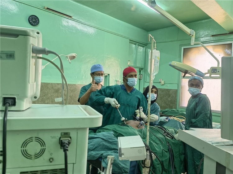 隊長蔣國慶（左一）關(guān)注當(dāng)?shù)蒯t(yī)生手術(shù)情況。中國援桑醫(yī)療隊供圖