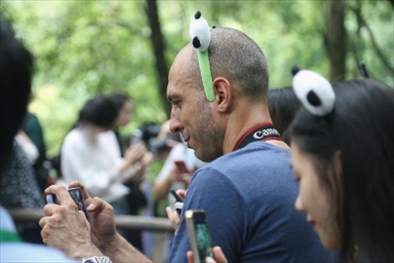 俄羅斯《俄羅斯報(bào)》視覺內(nèi)容編輯阿爾圖爾·杰魯諾夫在拍攝熊貓。（李佩藺 攝）