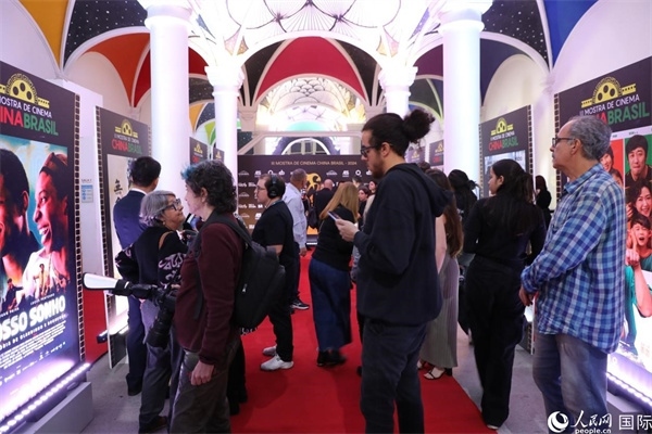 為期4天的第三屆中國(guó)－巴西電影展期間，來(lái)自中巴兩國(guó)的14部參展影片受到巴西電影愛(ài)好者和社會(huì)各界人士好評(píng)，圖為當(dāng)?shù)赜^眾在影展舉辦地巴西里約熱內(nèi)盧勞拉—阿爾維姆文化之家的迎賓廳欣賞參展電影海報(bào)。 人民網(wǎng)記者 陳一鳴攝