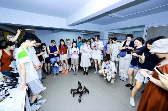 8月25日，中外青年在浙江杭州觀看機(jī)器人表演。新華社發(fā)（清華大學(xué)供圖）