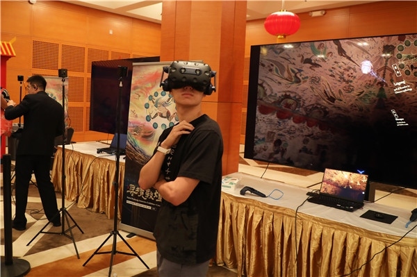 1、在本次活動的展覽現(xiàn)場，敦煌研究院與騰訊展示了“數(shù)字藏經(jīng)洞”和“尋境敦煌”等創(chuàng)新互動產(chǎn)品。圖為當(dāng)?shù)孛癖娡ㄟ^VR虛擬游覽洞窟。 人民網(wǎng)記者 李志偉攝