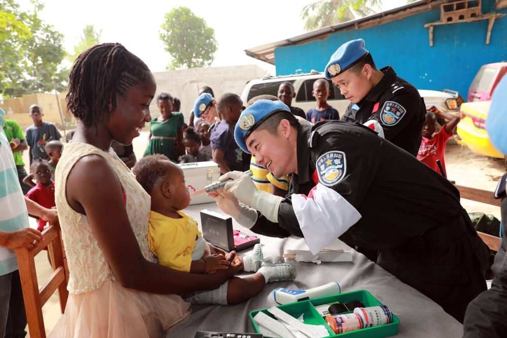 2017年12月28日，在利比里亞蒙羅維亞，中國(guó)維和警察防暴隊(duì)醫(yī)療人員為兒童做口腔檢查。