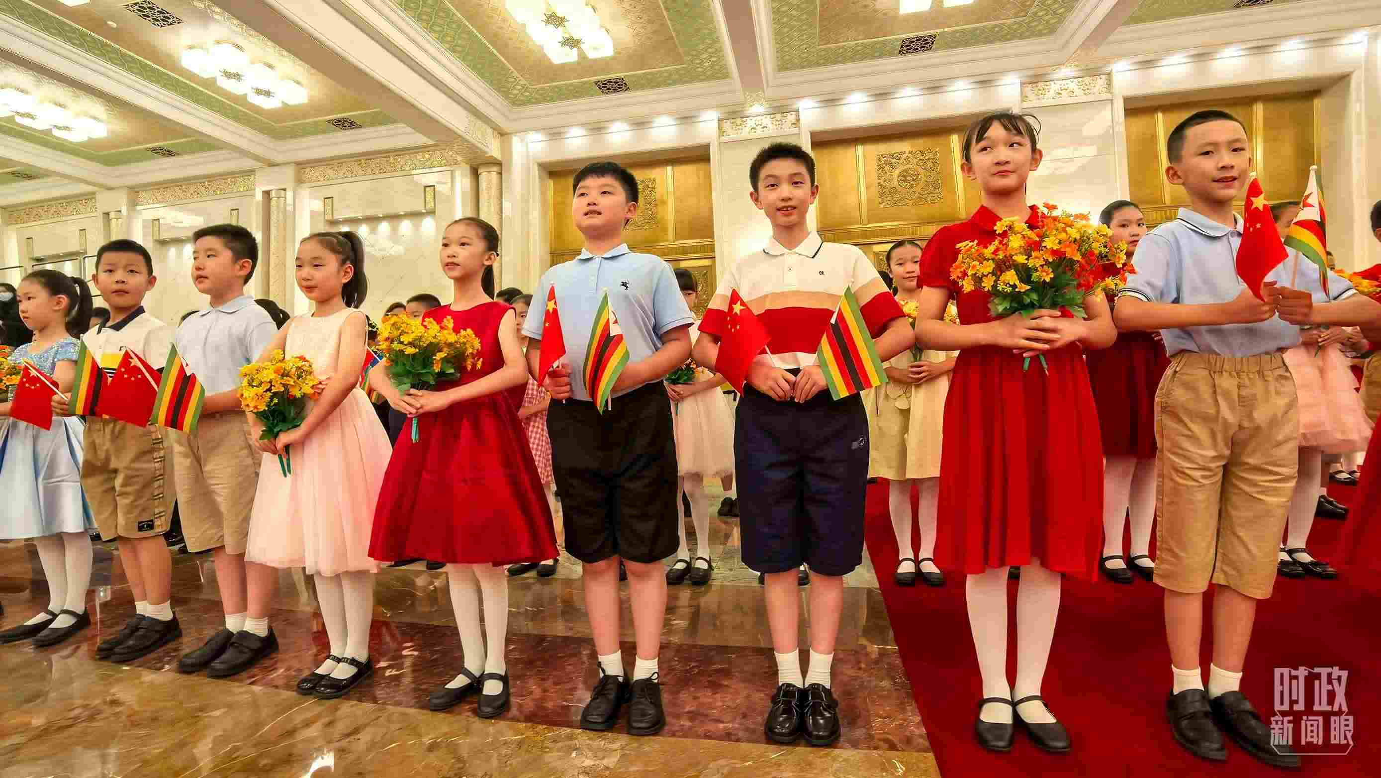 △現(xiàn)場(chǎng)歡迎津巴布韋總統(tǒng)訪華的青少年。（總臺(tái)央視記者鐘銳拍攝）