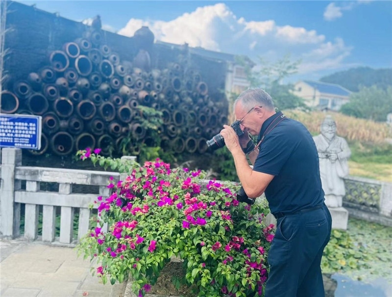 遠(yuǎn)處黔北民居錯(cuò)落有致，近處一只黑色的蝴蝶穿梭于粉紫色三角梅花叢間隙，與俄羅斯“大歐亞”總編輯弗拉基米爾·別列日內(nèi)赫的鏡頭玩起了捉迷藏，“你追我逃，不亦樂(lè)乎”。（張亞欣攝）