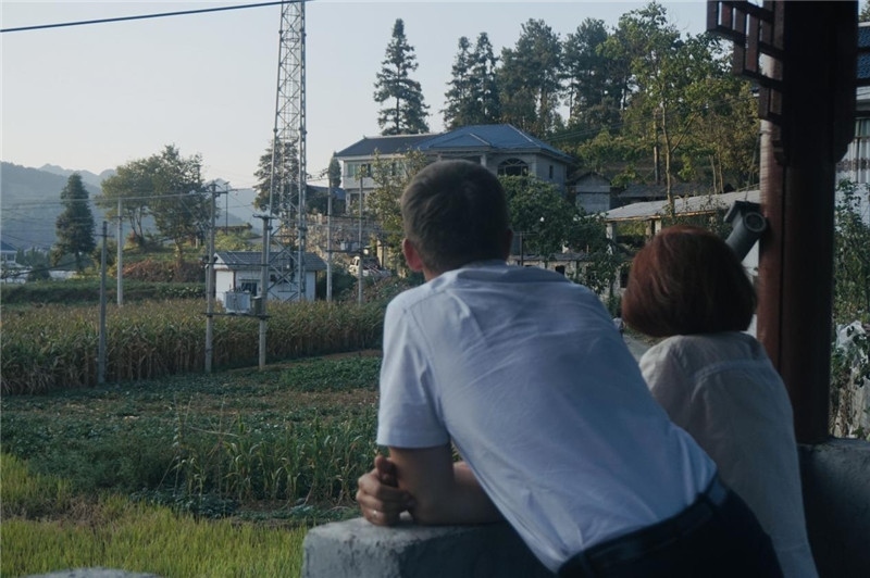 望得見(jiàn)山，看得見(jiàn)水，記得住鄉(xiāng)愁。每個(gè)人心中都有一個(gè)屬于自己的“花茂村”，在這方心田，走遍千山萬(wàn)水，鄉(xiāng)音未改鬢毛衰。吉爾吉斯斯坦《比什凱克晚報(bào)》第一副總編輯妮娜·尼奇博洛娃與《中國(guó)與俄羅斯》雜志社社長(zhǎng)奧列格·別列日內(nèi)赫攝在花茂村民居屋檐下并肩佇立，眺望山水，尋覓鄉(xiāng)愁。（李光裕攝）