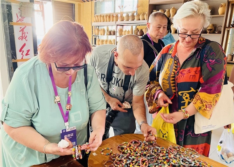 歐亞媒體考察團(tuán)成員在母氏陶藝館內(nèi)挑花了眼，色彩絢麗、質(zhì)地均勻的陶藝手串讓他們愛(ài)不釋手?！斑@里的東西都太實(shí)惠了！”塔吉克斯坦《索格特真理報(bào)》政論部主任娜塔利婭·多羅費(fèi)耶娃說(shuō)?；宓奶厣a(chǎn)品物美價(jià)廉，讓考察團(tuán)成員為家人好友買到了心儀的禮物，也為此次以四川成都為起點(diǎn)，路經(jīng)南充、廣安至貴州遵義的考察行程畫上了圓滿句號(hào)。（張亞欣攝）