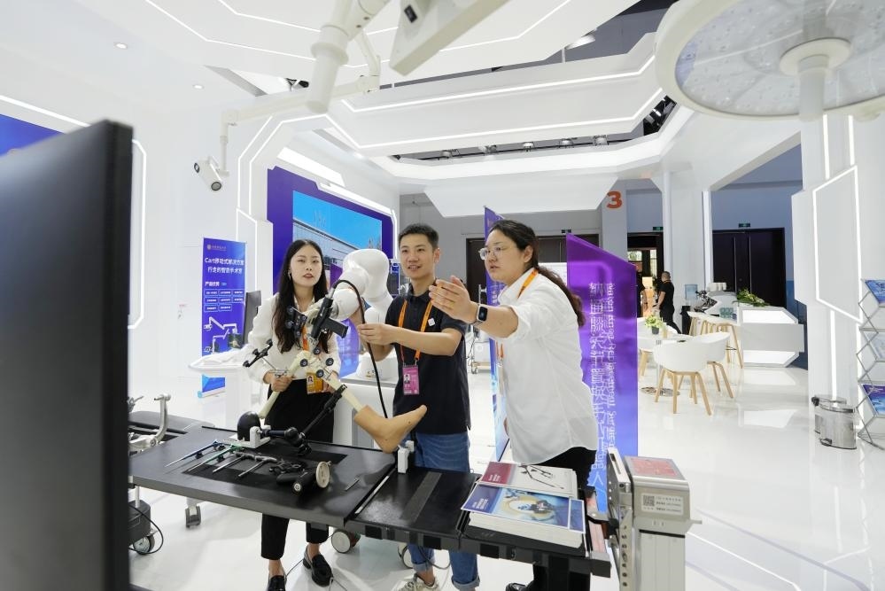 9月11日，一位媒體記者（中）在2024年服貿(mào)會國家會議中心會場體驗北京納通科技集團(tuán)有限公司的膝關(guān)節(jié)置換手術(shù)機(jī)器人。新華社記者鞠煥宗 攝