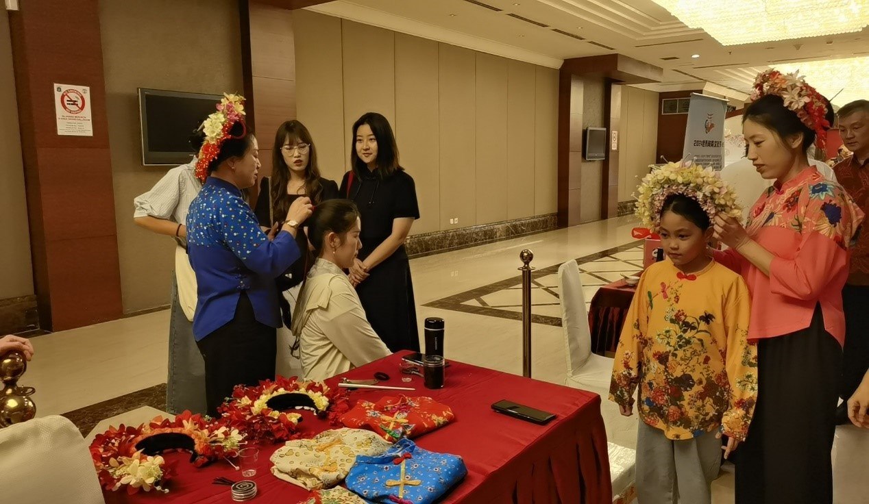 阿拉扎大學(xué)孔子學(xué)院志愿者老師向傳承人學(xué)習(xí)簪花圍。阿拉扎大學(xué)孔子學(xué)院供圖