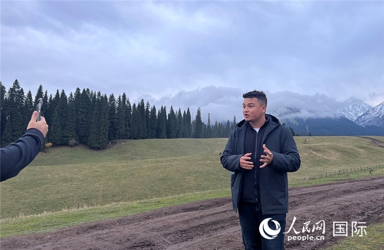 在庫爾德寧，吾買爾江被雪山美景震撼，即興錄制了短視頻作品。人民網(wǎng)記者曾書柔攝