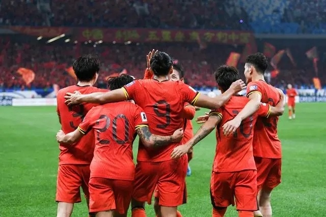 10月15日晚，張玉寧（9號(hào)）進(jìn)球后與隊(duì)友擁抱慶祝。新華社記者 李紫恒攝