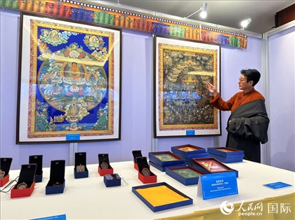 熱貢藝術(shù)國家級代表性傳承人夏吾角向嘉賓介紹作品。人民網(wǎng)記者 簡承淵攝