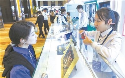 在北京麗澤商務(wù)區(qū)，工作人員（右一）介紹數(shù)字人民幣SIM卡硬錢包。新京報(bào)記者 陶冉攝