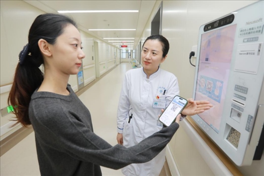 醫(yī)護人員引導患者在自助機前辦理自助入院手續(xù)。圖片來源：山東第一醫(yī)科大學第二附屬醫(yī)院