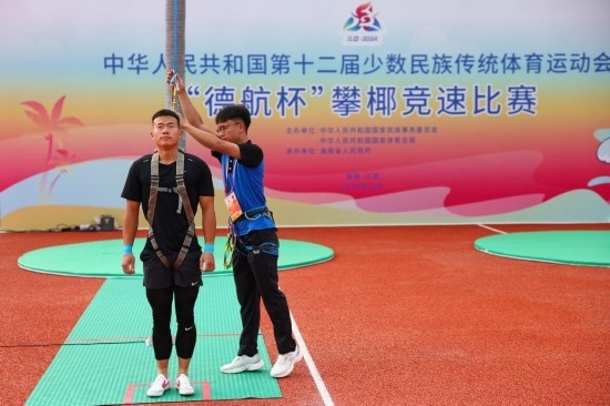 11月23日，工作人員為上海隊(duì)選手付樂樂（左）系安全繩。新華社記者 楊植森 攝