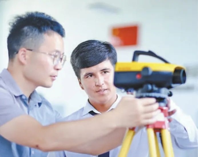 在塔吉克斯坦首都杜尚別的魯班工坊，來自天津城市建設管理職業(yè)技術學院的老師（左）為當?shù)貙W生提供指導。新華社記者 鄭開君 攝