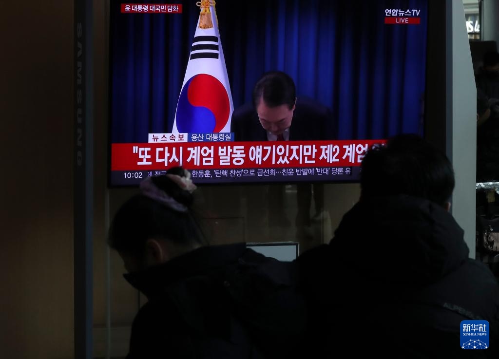 12月7日，在韓國首爾火車站，民眾觀看總統(tǒng)尹錫悅發(fā)表講話的電視畫面。新華社記者 姚琪琳 攝