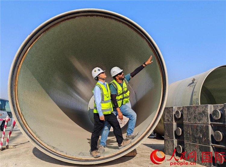 工作人員在察看輸水管情況。人民網(wǎng)記者 管克江攝